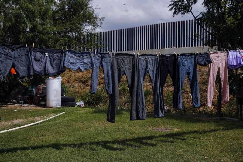 Ropas secándose en el patio de una casa junto a la valla fronteriza entre EE.UU. y México en Brownsville, Tejas
