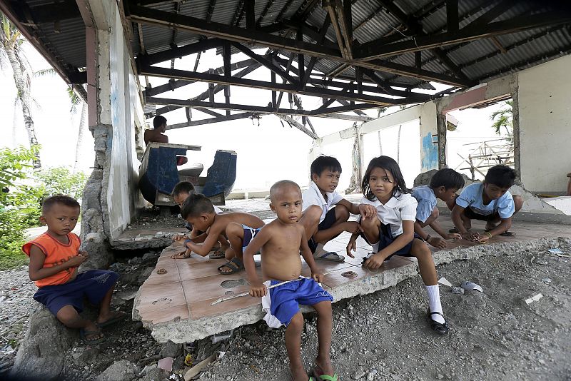 Niños filipinos juegan en las ruinas de una casa en San José, dañada por el paso del tifón