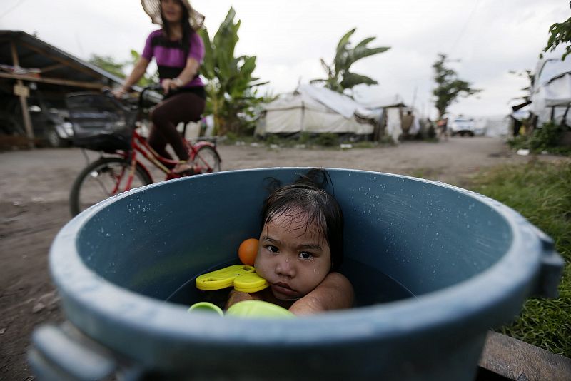 Kyra Marie, de 3 años, se toma un baño en un campo de desplazados en Leyte (Filipinas)