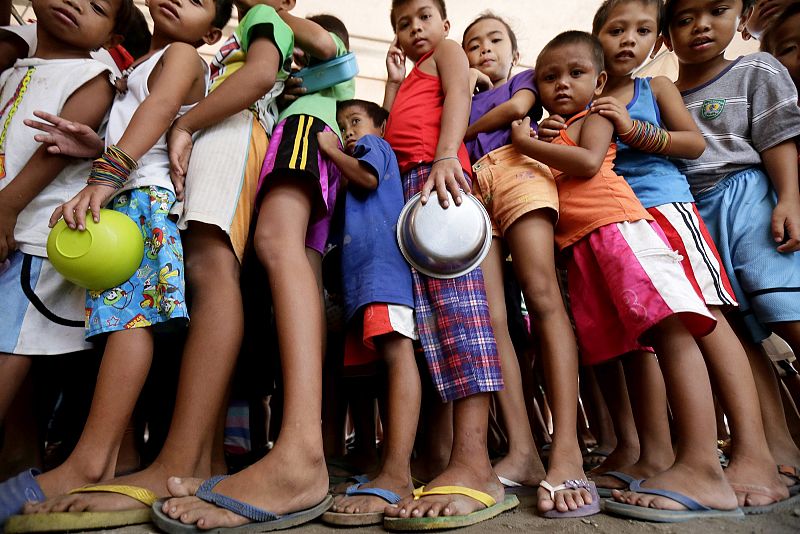 Niños hacen cola para recibir comida en un campo de desplazados en Leyte (Filipinas)