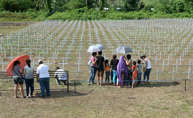 Familiares de las víctimas del tifón visitan el cementerio en Tacloban