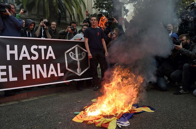 Manifestantes antiseparatistas queman la bandera independentista catalana, la 'estelada', en una concetnración en Barcelona.