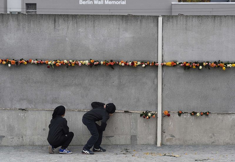 Dos niños miran a través del muro de Berlín 25 años después de su caída