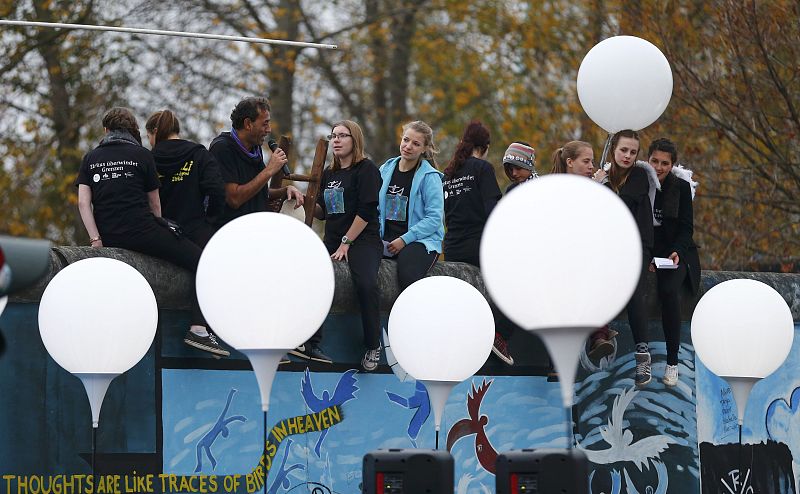 Varias personas subidas a un trozo del muro de Berlís 25 años después de su caída