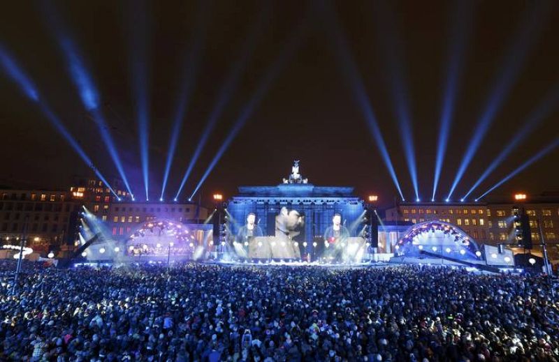 El actor alemán Jan Josef Liefers, subido en un escenario frente a la Puerta de Brandenburgo, en Berlín.