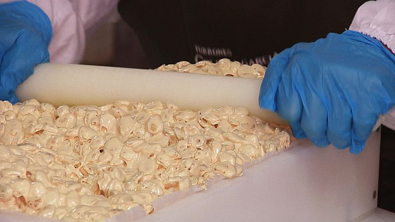 Para hacer el turrón de Jijona la masa se estampa en bandejas para que se enfríe, se pasa por este molino de piedra que tritura las almendras y por esta batidora gigante hasta que quede un producto mucho más líquido.