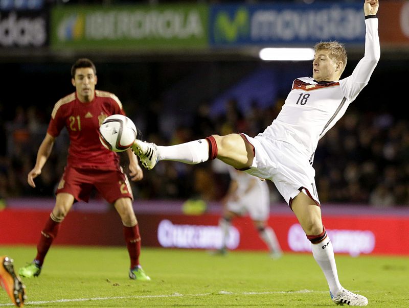 El centrocampista de Alemania, Toni Kroos (d), controla la pelota ante la mirada de Bruno Soriano.