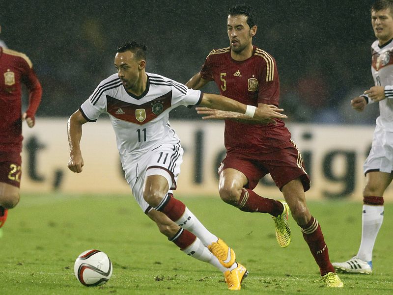 El jugador alemán Karim Bellarabi intenta marcharse del marcaje de Sergio Busquets.