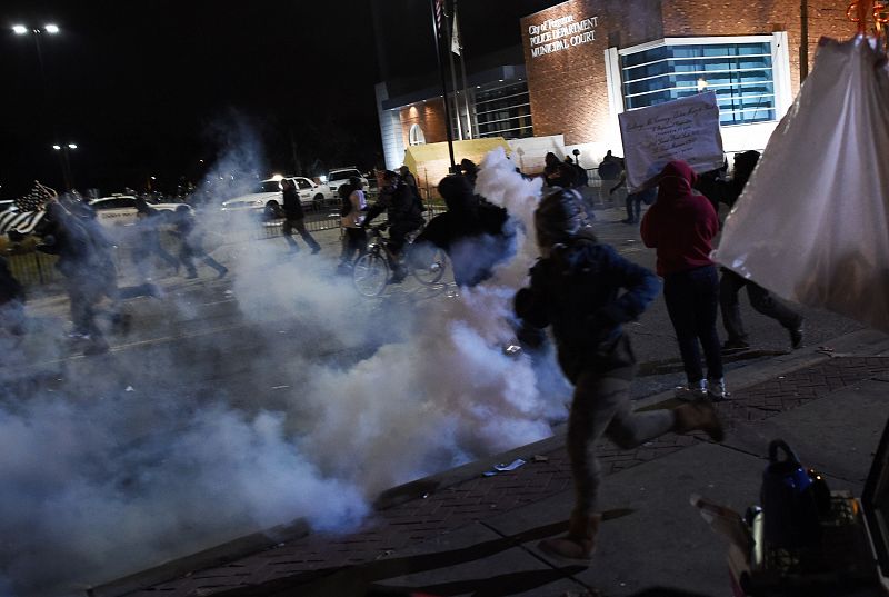 Los manifestantes huyen de los gases lacrimógenos lanzados por la policía en Ferguson.