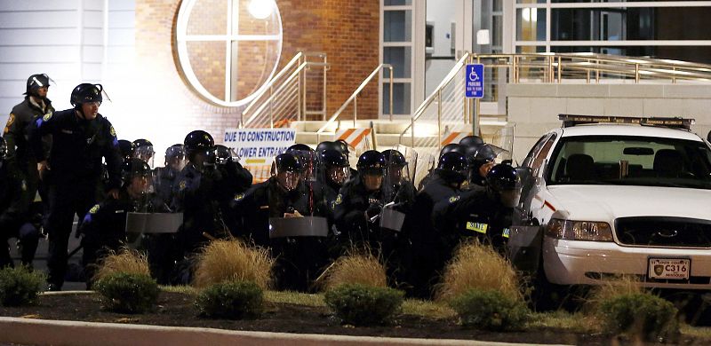 Unos agentes permanecen a las afueras del departamento de policía de Ferguson.