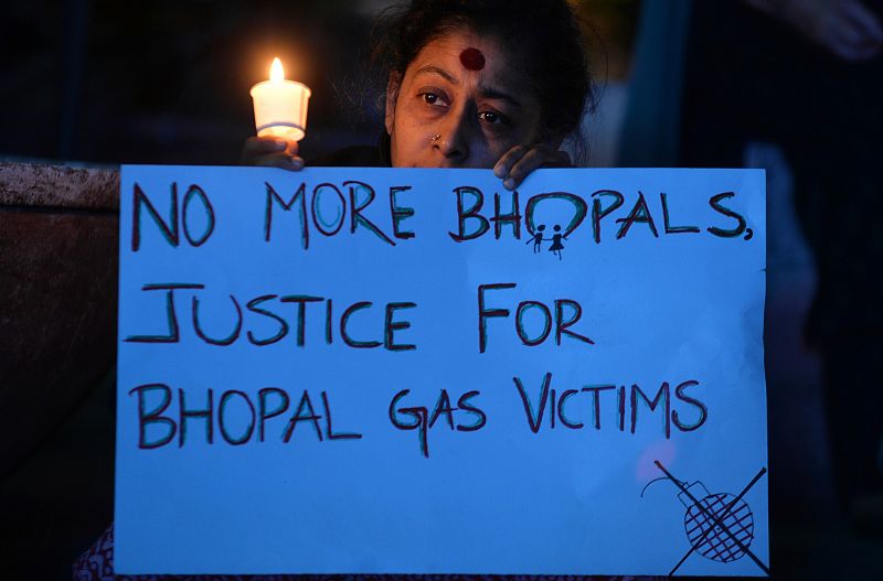 Una mujer muestra una pancarta con el lema "No más Bhopals, justcia para las víctimas del gas" en la vigilia celebrada en recuerdo del accidente.