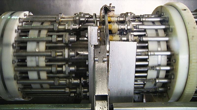 Esta máquina que funciona a toda velocidad es la encargada de quitarle el hueso a la aceituna y meterle el relleno ¿  ¡más de 1200 al minuto!. La deshuesadora vacía la aceituna en dos movimientos. Primero una boquilla hace el corte por el que sale el