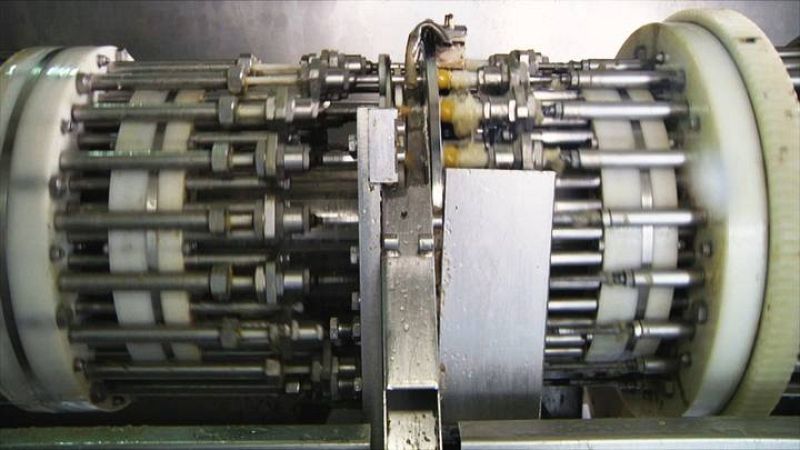 Esta máquina que funciona a toda velocidad es la encargada de quitarle el hueso a la aceituna y meterle el relleno ¿  ¡más de 1200 al minuto!. La deshuesadora vacía la aceituna en dos movimientos. Primero una boquilla hace el corte por el que sale el