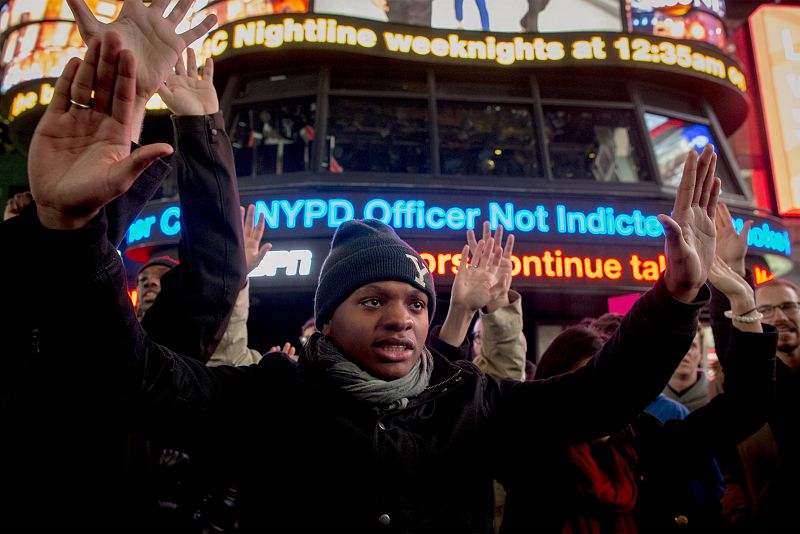 Manifestantes alzan sus manos en Times Square en protesta por la decisión del gran jurado sobre el caso de Eric Garner.