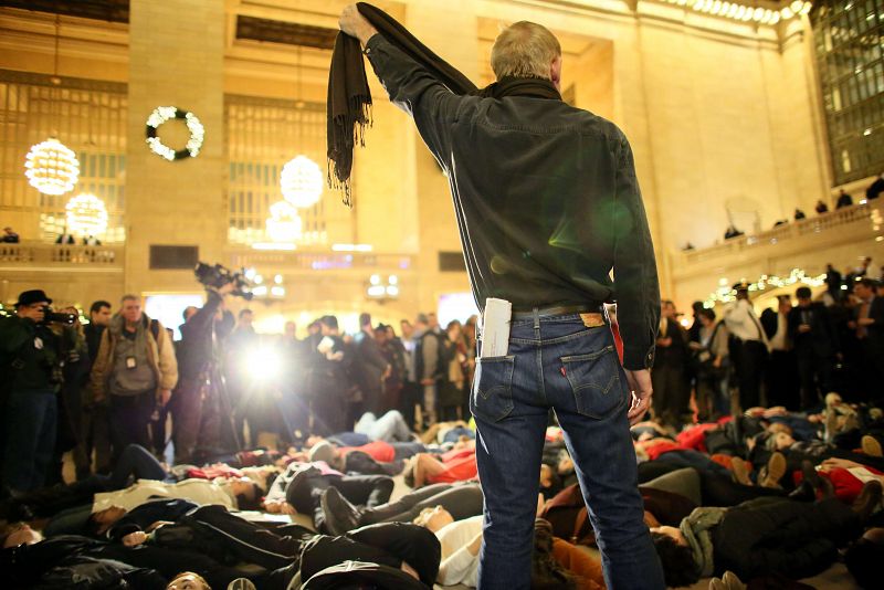 Un hombre se ahoraca simbólicamente con una bufanda durante las protestas en la estación Grand Central de Nueva York tras la decisión del gran jurado en señal de protesta.