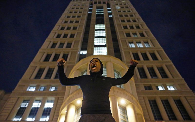 Una joven levanta los brazos ante la corte de justicia de St. Louis en Missuri en apoyo a las manifestaciones de Nueva York.