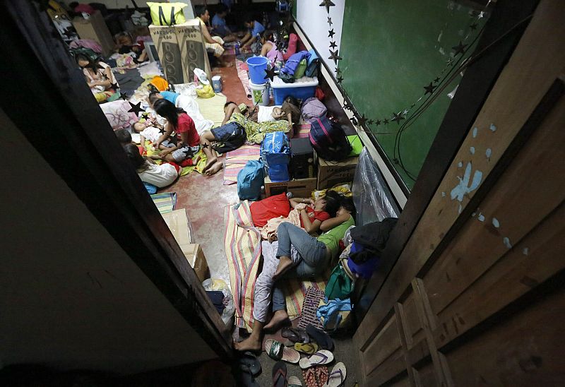 Varias familias filipinas se refugian en una escuela en el centro de la ciudad de Tacloban por el paso del tidón.