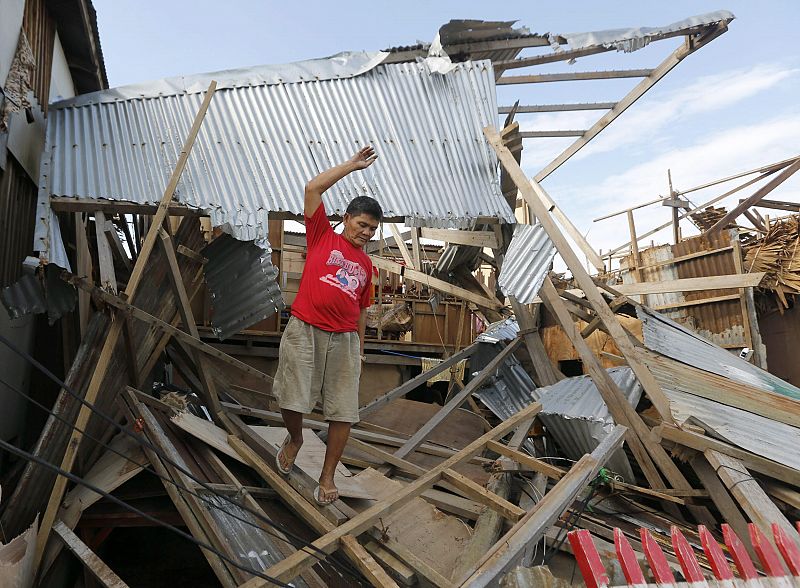 Un hombre camina sobre los restos de su casa en Dolores, en la isla de Samar