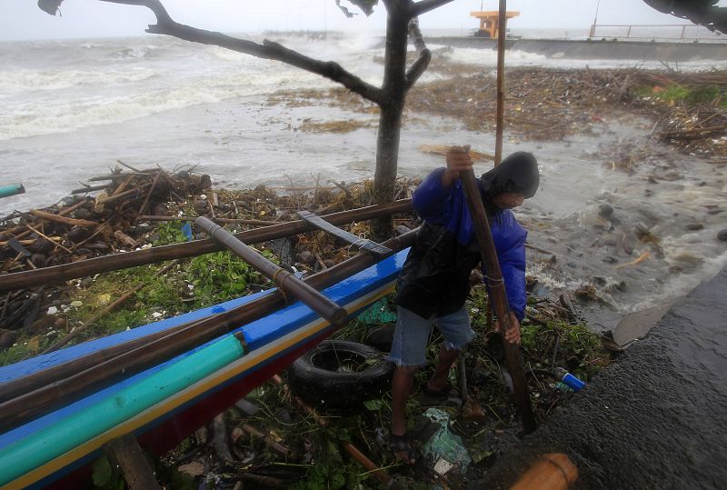 Un pescador limpia el lugar donde tiene su barca en la ciudad de Atimonan