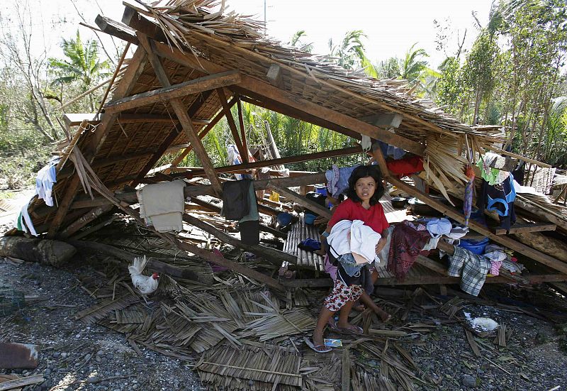 Una mujer ante los restos de su casa en Can-avid, en la isla de Samar
