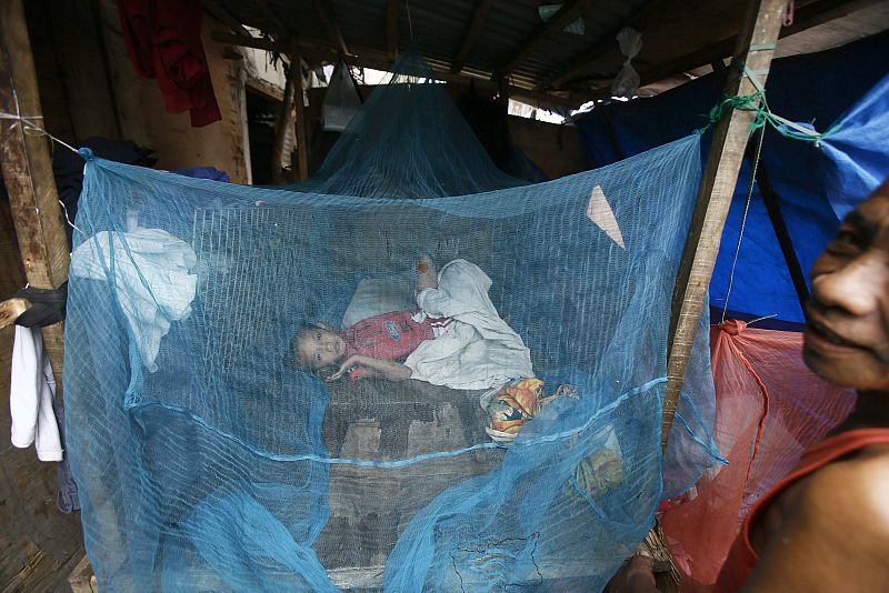 Una familia descansa en un refugio construido fuera de un centro de evacuación en un suburbio de Manila