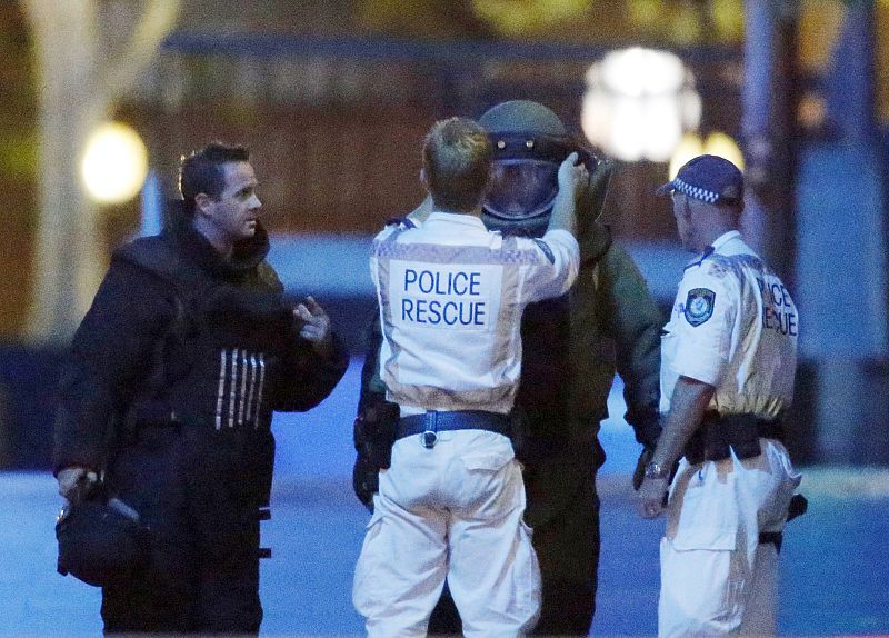 Un oficial de Policía ayuda a colocarse el equipo de asalto a otro miembro de las fuerzas de seguridad