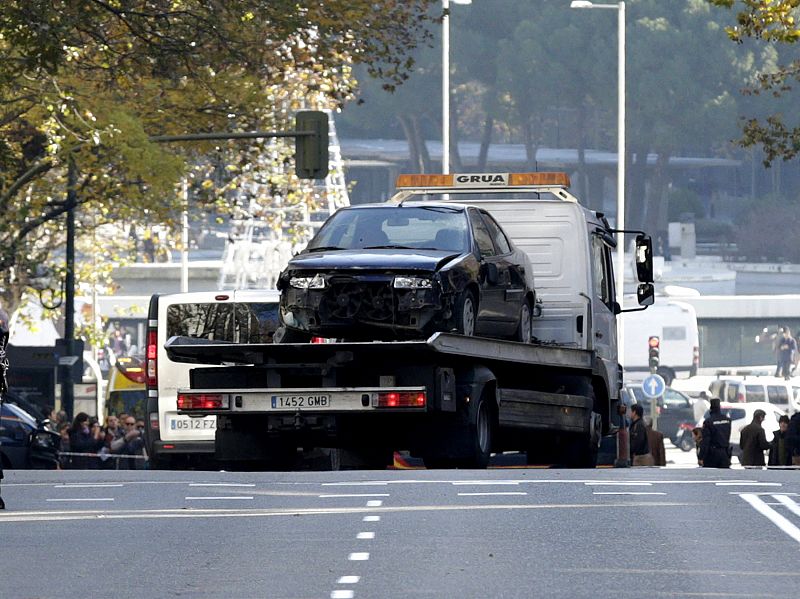 La grúa se lleva el coche que un hombre ha estrellado contra la sede del PP en Madrid