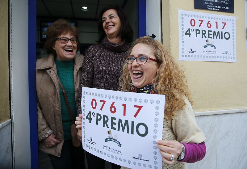 Rosario Pino, empleada de una administración de Málaga sostiene un cartel con el cuarto premio, el 07617, que ha repartido 240.000 euros.