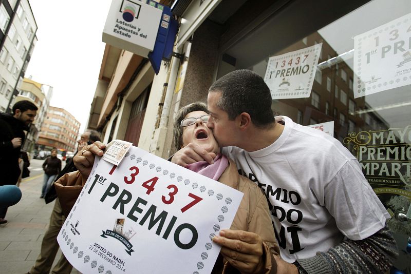 El dueño de la administración de A Coruña donde ha tocado el Gordo de la lotería de Navidad 2014, muy contento, besa y abraza a su tía. CARBALLO Y A CORUÑA