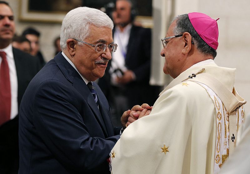 El presidente palestino, Mahmud Abás, saluda al patriarca latino de Jerusalén, Fouad Twal, durante la misa de Navidad celebrada en Belén