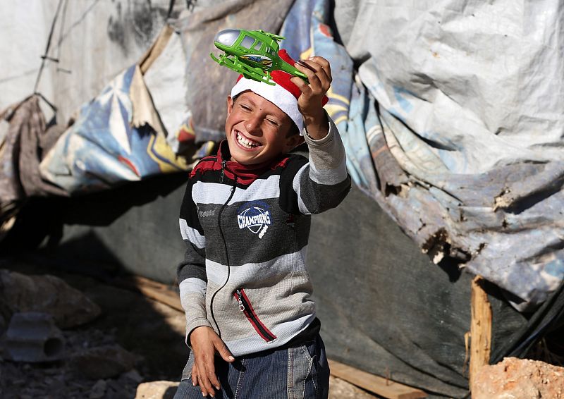 Un niño refugiado de la guerra de Siria juega con uno de los juguetes que ha repartido la ONG SAWA en el campo de refugiados de Bar Elias, en Líbano