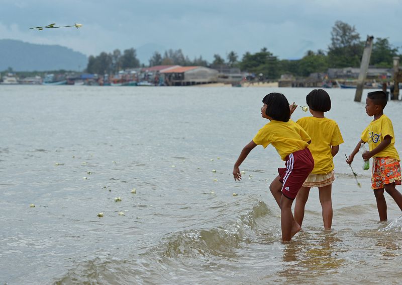 Niños arrojan flores al mar en Phang-nga, Tailandia