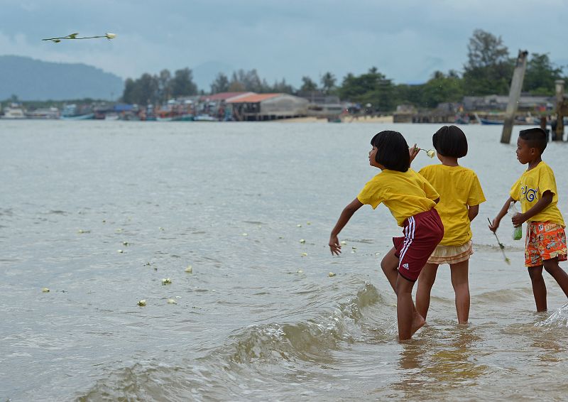 Niños arrojan flores al mar en Phang-nga, Tailandia