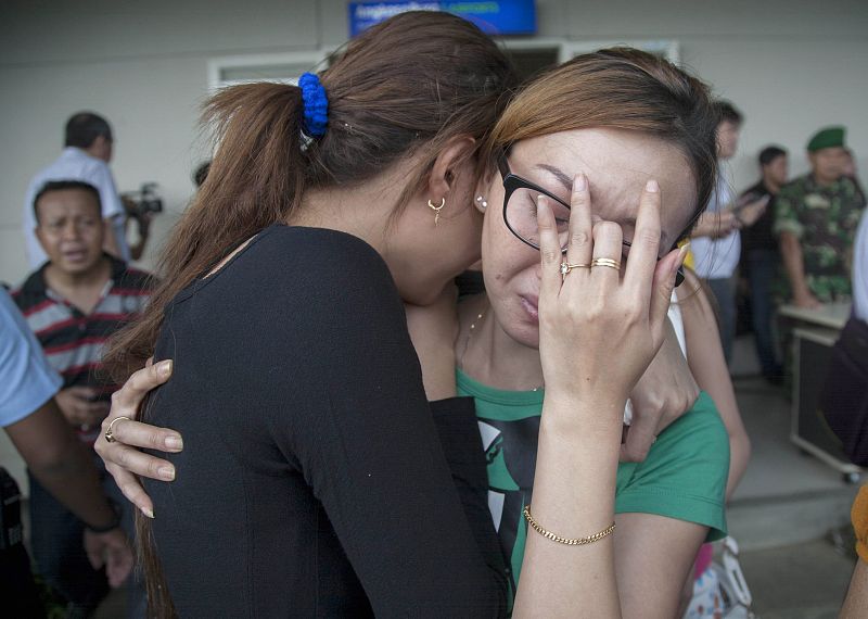 Varios familiares de la personas que viajaban en el AirAsia lloran al enterarse de que el avión ha desaparecido.