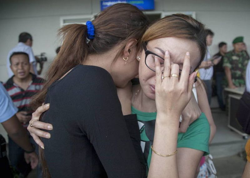 Varios familiares de la personas que viajaban en el AirAsia lloran al enterarse de que el avión ha desaparecido.