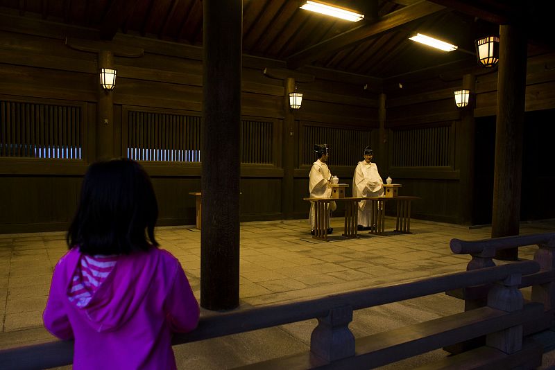 Una niña observa en Tokio a unos sacerdotes sintoístas en una ceremonia ritual de fin de año.