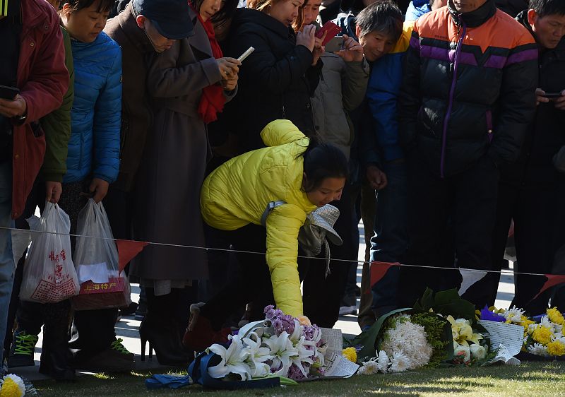 Otra mujer deposita un ramo de flores cerca del lugar en el que se produjo la estampida humana.