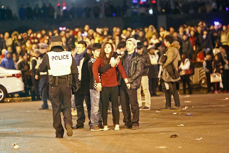 Un hombre abraza a una mujer después de la estampida en el malecón de Shanghái