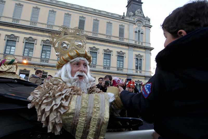 El rey Melchor saluda a un niño a su llegada a Barcelona