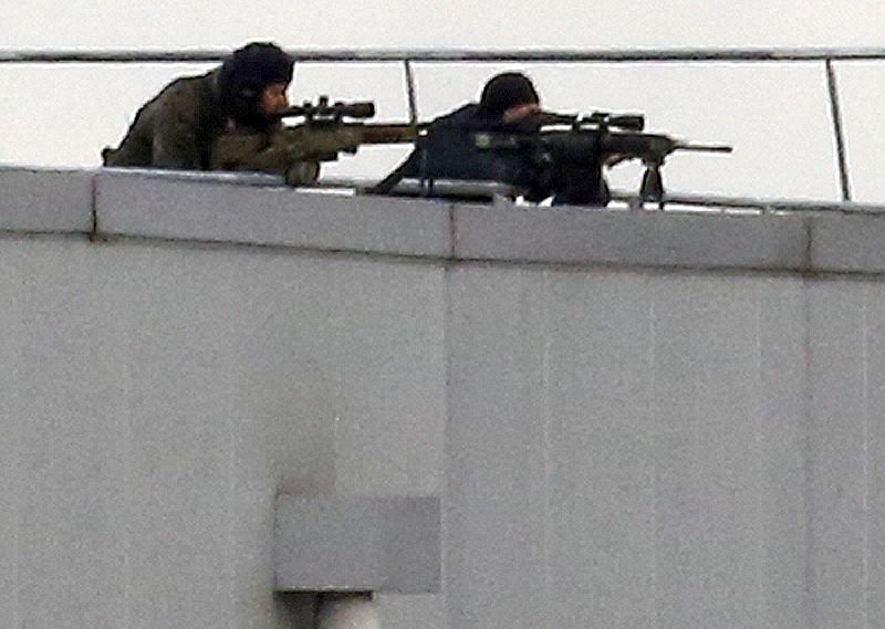 Dos francotiradores de las fuerzas especiales francesas vigilan el escenario del secuestro en la imprenta.