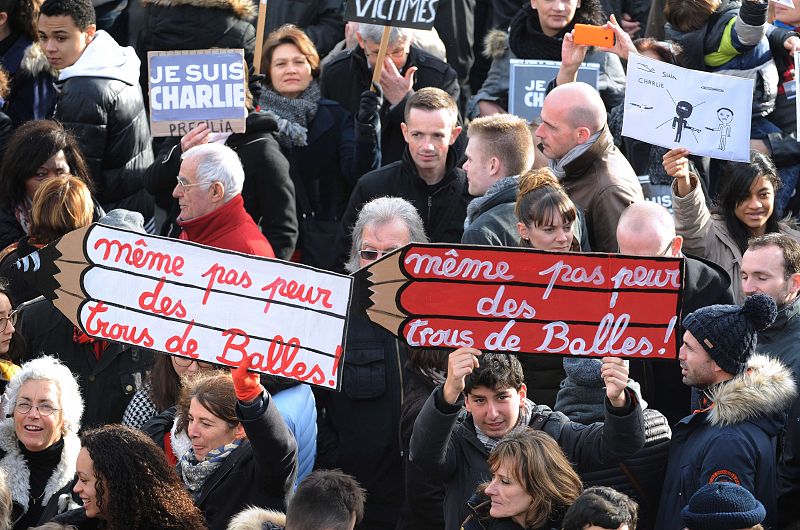 Varios ciudadanos franceses llevan en la manifestación lápices en homenaje a los doce fallecidos en la masacre de la revista 'Charlie Hebdo'.