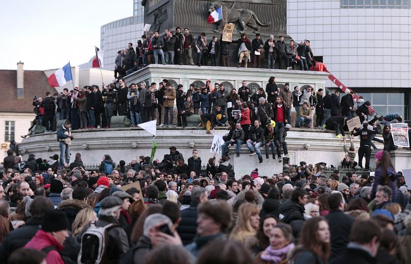 Los manifestantes ondean banderas francesas en la plaza de Bastilla en la 'marcha republlicana' de París.