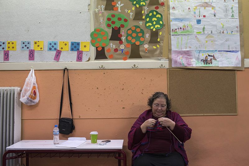 Una mujer hace ganchillo en un centro de votación en Atenas (Grecia).