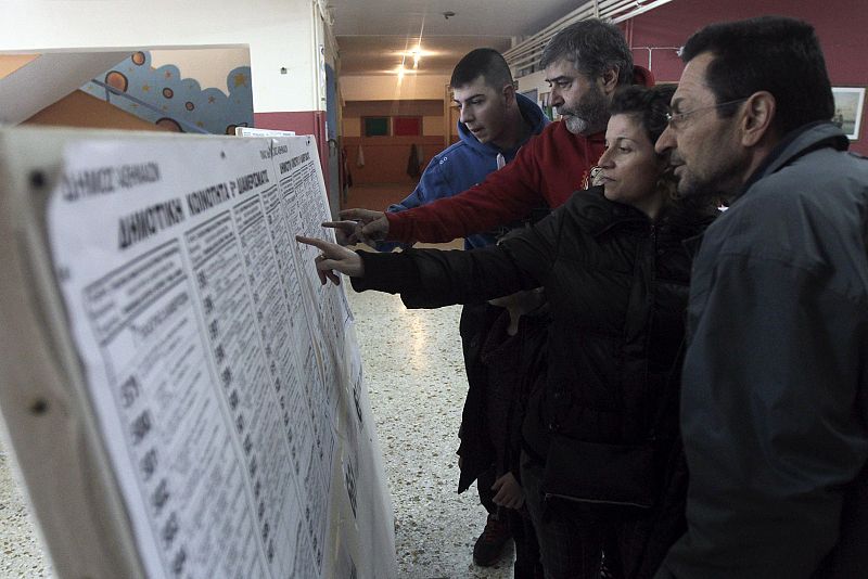 Varias personas miran las listas de los candidatos en las elecciones de Grecia.