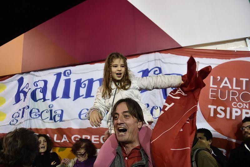 Un hombre con una niña celebran los primeros resultados de las elecciones griegas.