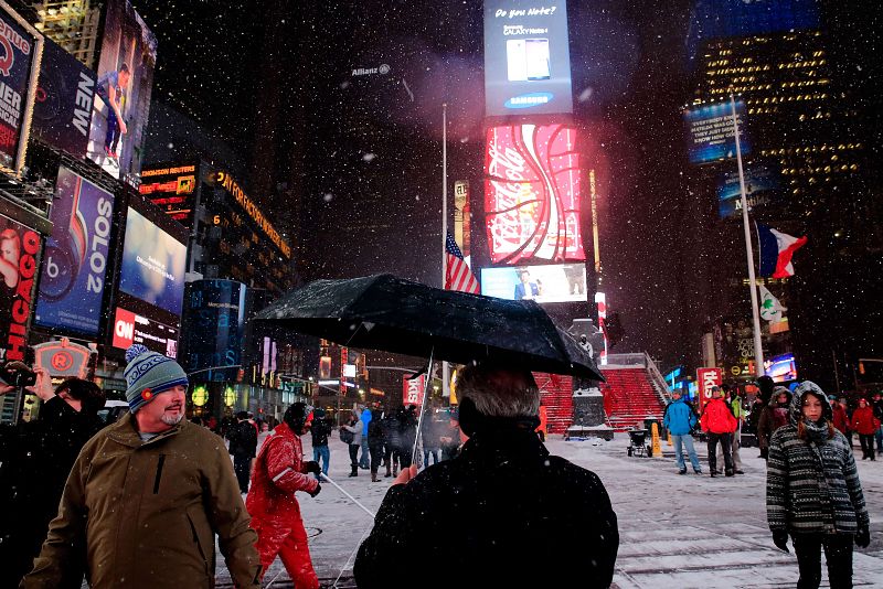 Peatones caminan sobre una nevada Times Square en Nueva York.