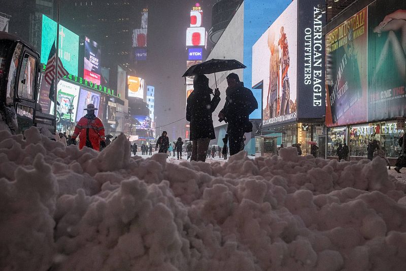 Dos viandantes se refugian de la nieve bajo un paraguas en Times Square, Nueva York.