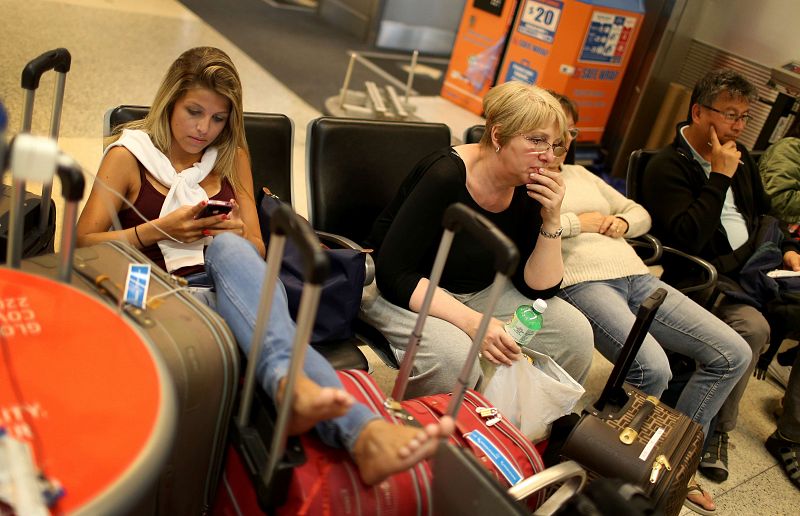 Una pasajera espera en el aeropuerto de Miami tras el retraso de su vuelo a Nueva York.