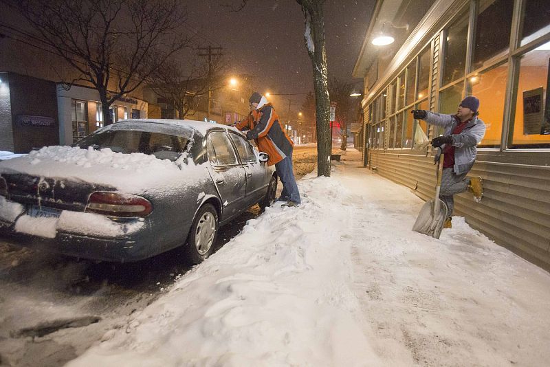 Dos ciudadanos limpian su conche de nieve en New Haven, Connecticut.