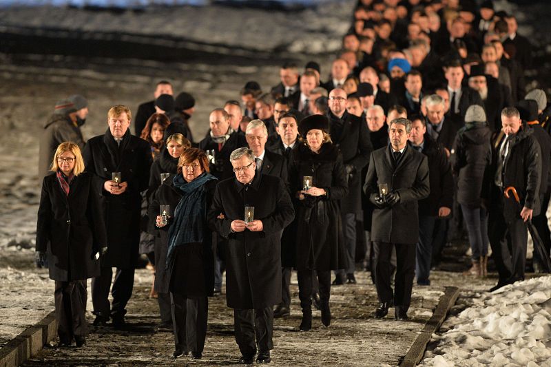 El presidente polaco, Bronislaw Komorowski, encabeza junto a su mujer una marcha en la entrada del campo de concentración.